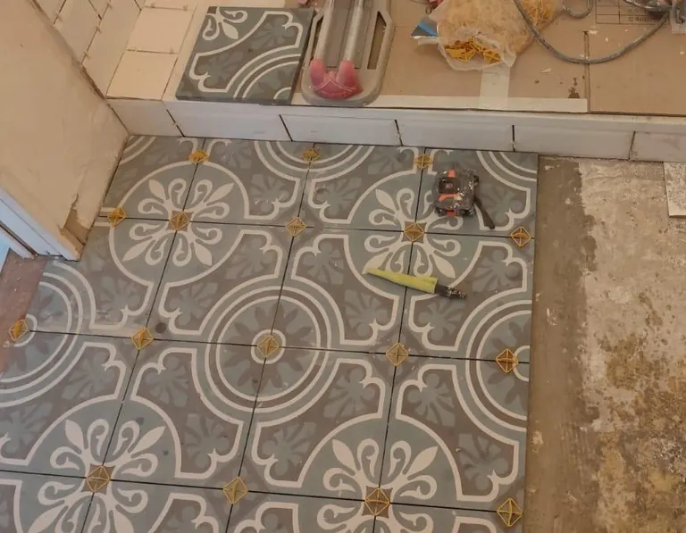 Pose du sol en carreaux effet ciment, en cours de chantier